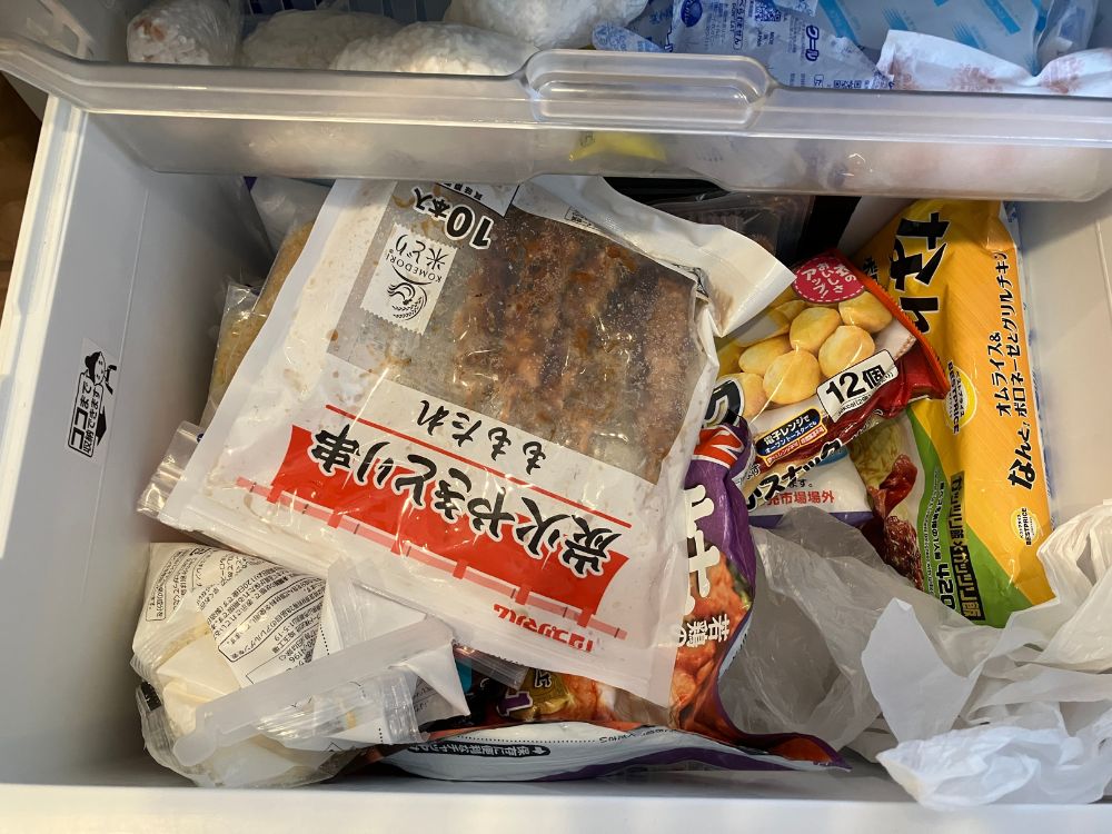 冷凍庫下段（ビフォー）。冷凍食品が上下方向に重なっている。
